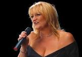 Sue Rivers singing into a microphone